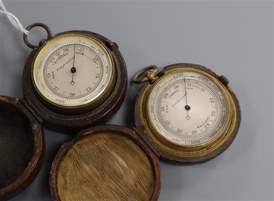 Two pocket barometers in leather cases